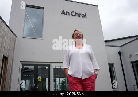 Londonderry, Regno Unito. 15 settembre 2021. L'operaio sociale Geraldine Doherty si trova di fronte al centro educativo e culturale 'An Choi'. Questo è irlandese e significa "cuore della comunità” in tedesco. Nella disputa sulle regole post-Brexit, l’Irlanda del Nord è diventata l’eterno osso della contesa tra Bruxelles e Londra. Ciò lascia il segno nella regione dell'ex guerra civile. Le tensioni tra protestanti e cattolici sono nuovamente aumentate dalla Brexit. (Al dpa 'del mostro UE e vincitori della Brexit - Irlanda del Nord tra i fronti') credito: Larissa Schwedes/dpa/Alamy Live News Foto Stock