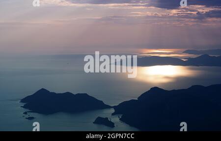 Bellissimo panorama aereo dalla cima di Babadag di alte montagne che si innalzano sul mare Mediterraneo al tramonto vicino Oludeniz Blue Lagoon Coast in Tu Foto Stock