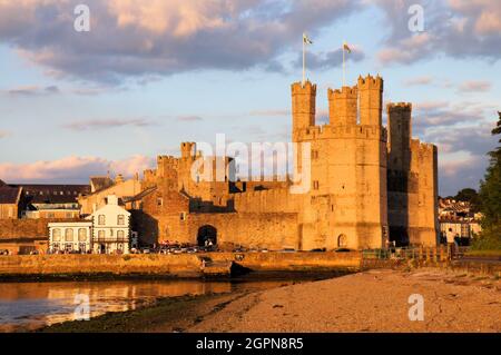 Caernarfon Castello, parti della città e riflessi nel mare (fiume) poco prima del tramonto a Caernarfon Gwynedd, Galles Foto Stock