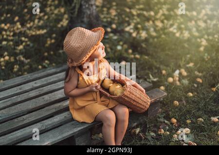 Bambina che tiene il cestino di vimini con le pere Foto Stock