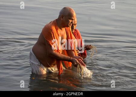 I devoti indù eseguono 'Tarpan', o rituali di Pind Daan per la pace delle anime degli antenati, sulla riva di Yamuna a Nuova Delhi. Foto Stock