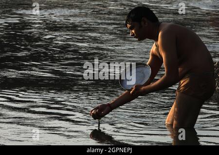 I devoti indù eseguono 'Tarpan', o rituali di Pind Daan per la pace delle anime degli antenati, sulla riva di Yamuna a Nuova Delhi. Foto Stock