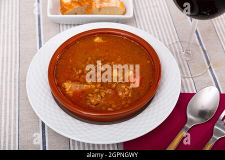 Piatto di cucina spagnola Lentejas con chorizo, vitello stufato in salsa di pomodoro con chorizo servito su piatto di ceramica Foto Stock
