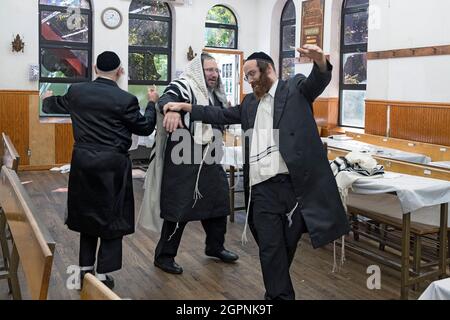 Gli ebrei ortodossi ballano per celebrare la gioiosa vacanza di Sukkos. In una sinagoga a Williamsburg, Brooklyn, New York City. Foto Stock