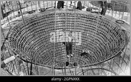 Operai che costruiscono i mescolatori preliminari a Shoreham Cement Works. John Laing &amp; Son Ltd ha costruito una nuova fabbrica di cemento per la Associated Portland Cement Manufacturers Ltd in questa cava di gesso in Upper Beeding vicino Shoreham-by-Sea, con lavori in cava a partire dal febbraio 1949. I lavori sul sito erano vari e complessi e includevano la costruzione di edifici presso le cementerie, le modanature ferroviarie e un impianto di movimentazione del carbone. L'etichetta digitata sotto la fotografia riporta "completamento dell'anello interno in acciaio al lato inferiore della trave ad anello. Gli uomini al fondo si stanno preparando a portare il rivestimento interno Foto Stock