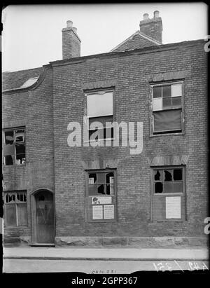 Little Park Street, Coventry, 1941. L'esterno di 92 Little Park Street mostra danni bomba alla facciata e avvisi relativi al razionamento e incursioni d'aria apparsi sulle tavole che coprono le finestre rotte. Il centro di Coventry è stato devastato dalle incursioni aeree nel novembre 1940. I bombardamenti lasciarono la cattedrale in rovina e distrussero gran parte del tessuto storico della città. Gran parte di Little Park Street è stata demolita. La Corte dei Magistrati occupa ora il sito di questa casa. Foto Stock