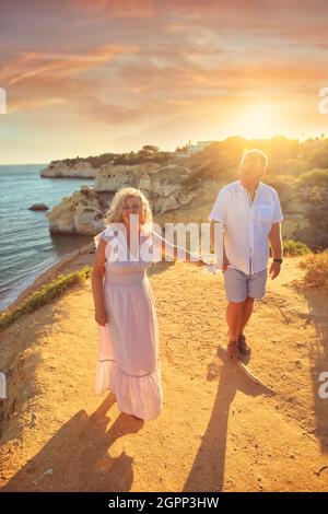 coppie anziane in amore passeggiate in riva al mare sulle scogliere Foto Stock