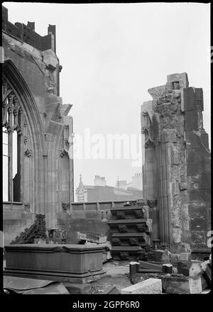 Cattedrale di Manchester, Manchester, 1942. L'angolo nord-ovest della Cappella Ely presso la Chiesa della Cattedrale di St Mary, o la Cattedrale di Manchester, che mostra danni alla bomba. La cattedrale era originariamente una chiesa parrocchiale collegiata, risalente tra il 1422 e il 1520, e divenne cattedrale nel 1847. Può contenere del materiale precedente ed è stato alterato nel 1814-1815, 1862-1868, 1885-1886 e nel 1898. Ha ricevuto danni da bomba nel 1940 ed è stato ricostruito e restaurato da Sir Hubert Worthington. La cattedrale ha una torre ovest con portico, una navata a sei campate con portici nord e sud, un coro a navata con cappelle fiancheggiata Foto Stock