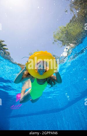 Spagna, Maiorca, donna sorridente che nuota in piscina con anello gonfiabile Foto Stock