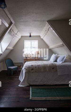 Antico trapunta floreale in camera da letto mansardata del cottage Suffolk. Foto Stock