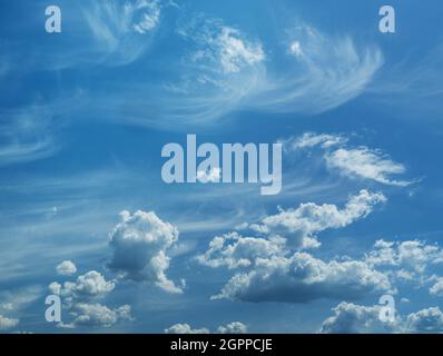 Alcune nuvole di cumuliformi e cirrus nel cielo azzurro pulito. Natura sfondo. Foto Stock