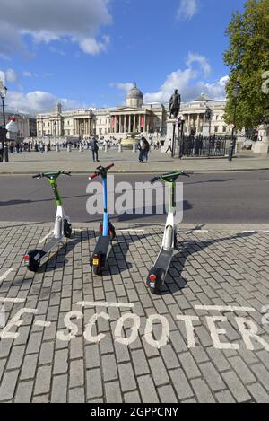 Londra, Inghilterra, Regno Unito. E-scooters a noleggio a Trafalgar Square Foto Stock