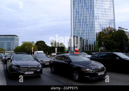 Bruxelles, Belgio. 30 settembre 2021. Gli autisti Uber guidano i loro taxi in un motociclo attraverso il centro della città durante una protesta contro il divieto del governo locale di utilizzare gli smartphone durante la guida a Bruxelles, in Belgio, il 30 settembre 2021. Credit: ALEXANDROS MICHAILIDIS/Alamy Live News Foto Stock