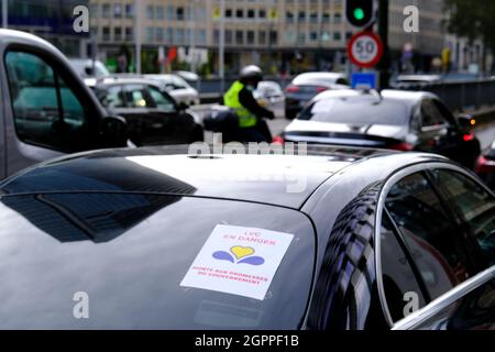 Bruxelles, Belgio. 30 settembre 2021. Gli autisti Uber guidano i loro taxi in un motociclo attraverso il centro della città durante una protesta contro il divieto del governo locale di utilizzare gli smartphone durante la guida a Bruxelles, in Belgio, il 30 settembre 2021. Credit: ALEXANDROS MICHAILIDIS/Alamy Live News Foto Stock