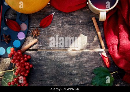 Natura morta estetica autunnale: Frutta, verdura e vernici brillanti con bastoncini di cannella, viburnum, petali di fiori e tazza di tè. Concetto di giorno del ringraziamento. Autunno piatto adagiare con ombre moderne e accoglienti. Foto Stock