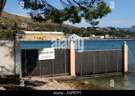 Il Pine Walk lungo la riva a Port de Pollenca, Maiorca, termina presso la zona militare spagnola (zona militar) e una base aerea attiva del governo. Foto Stock