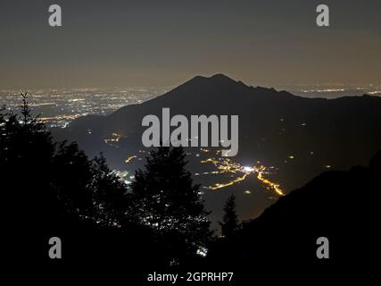 Monte Summano vicino alla città di Vicenza nel Nord Italia con le luci della città nella lontana pianura Padana Foto Stock