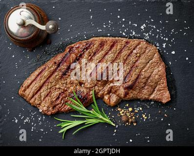 Striploin grigliato su tavola di pietra pronto per servire, vista dall'alto Foto Stock