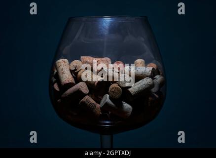 LA HABANA, CUBA - 31 agosto 2021: Un bicchiere grande trasparente con molti tappi di bottiglia di vino su sfondo blu Foto Stock