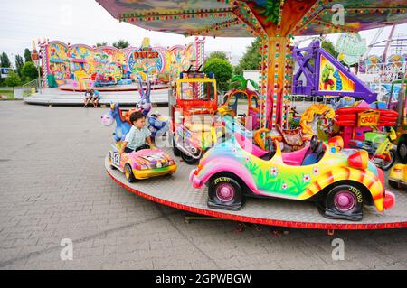 POZNAN, POLONIA - 24 luglio 2017: Una giostra colorata con bambino seduto in una fiera nella zona di Franowo. Foto Stock