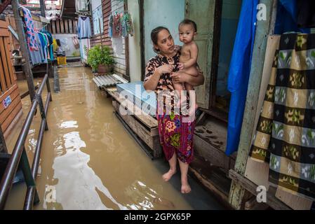 Nonthaburi, Tailandia. 30 settembre 2021. Una donna è visto portare un bambino in acqua allagata durante il dophomath.After tropicale tempesta di Dianmu, un diffuso di inondazioni in 30 province nel centro e nord-est della Thailandia. Il governo ha annunciato la situazione delle inondazioni in 9 province, tra cui Bangkok, Nonthaburi, Patum thani, Chai Nat, Sing Buri, Ang Thong, Ayutthaya, Sara Buri e Lop Buri. Che la situazione debba essere controllata giorno per giorno. (Foto di Peerapon Boonyakiat/SOPA Images/Sipa USA) Credit: Sipa USA/Alamy Live News Foto Stock