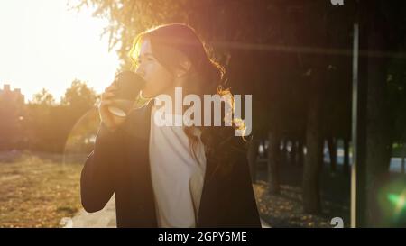 Una giovane donna con i flecks sul viso parla al telefono sopra la strada Foto Stock
