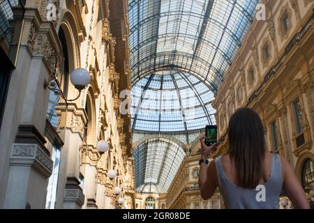 Turista femmina che fotografa con il cellulare della Galleria Vittorio in Italia vicino al Duomo di Milano Foto Stock