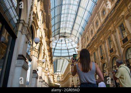 Turista femmina che fotografa con il cellulare della Galleria Vittorio in Italia vicino al Duomo di Milano Foto Stock