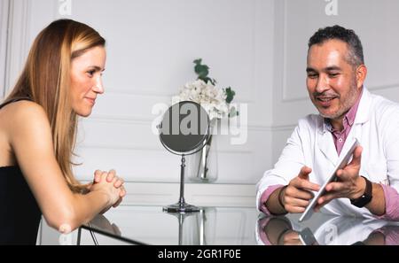 Un medico giovane che consulta una giovane donna Foto Stock