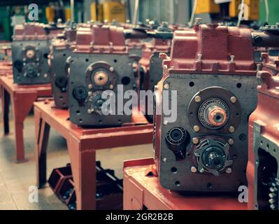 Cambi di trasmissione nel negozio della fabbrica di trattori, fuoco selettivo. Produzione di scatole ingranaggi. Componenti della macchina del trattore Foto Stock