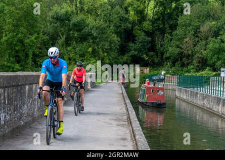 Ciclisti che attraversano l'acquedotto di Avoncliff, Wiltshire, Inghilterra Foto Stock