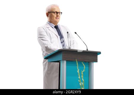 Medico maschio maturo che dà un discorso da una tribuna isolato su sfondo bianco Foto Stock
