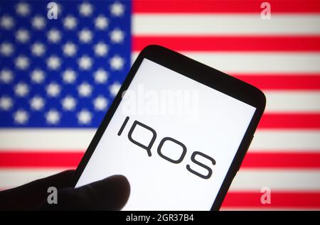 Ucraina. 30 settembre 2021. In questa illustrazione della foto viene visualizzato il logo IQOS sullo schermo di uno smartphone con la bandiera USA sullo sfondo. Credit: SOPA Images Limited/Alamy Live News Foto Stock