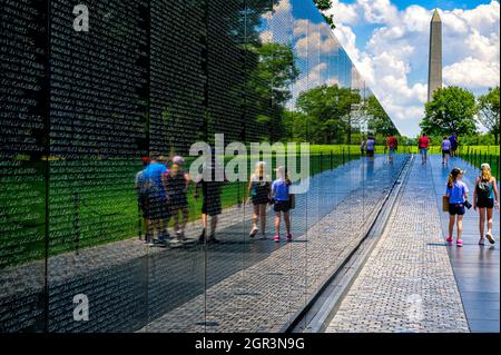 Riflessioni sul muro del Vietnam Veterans Memorial con il Washington Monument sullo sfondo Foto Stock