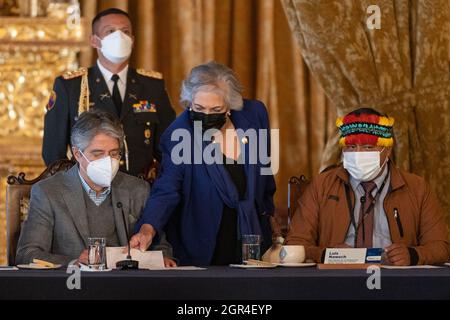 Un consigliere del presidente ecuadoriano Guillermo lasso gli pone un foglio davanti mentre ascoltava le osservazioni di apertura di Luis Nawech (a sinistra), presidente di un'organizzazione indigena della nazione Shuar.il presidente ecuadoriano Guillermo lasso ha dato il benvenuto ai leader della comunità indigena Shuar nel palazzo presidenziale della capitale del paese, Quito. Entrambe le parti hanno tenuto un incontro incentrato su problemi sanitari, educativi e ambientali. I capi di Shuar hanno anche menzionato la creazione di una nuova contea nella provincia di Morona Santiago nell'Amazzonia ecuadoriana. Foto Stock