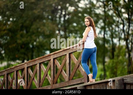 Donna bianca graziosa si erge nel parco di giorno. Foto Stock