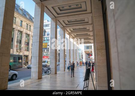 Berlino, Germania - Agosto 28 2017; Portico di negozi al dettaglio sulla strada della città con persone sfocate in movimento a piedi. Foto Stock