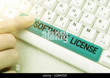 Licenza software con firma scritta a mano. Business idea strumento legale che regola la ridistribuzione del software digitando documento di certificazione concetto Foto Stock