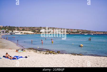 Malta: Una donna che si affaccia sul mare sulla spiaggia di Ghadira Bay. Foto Stock