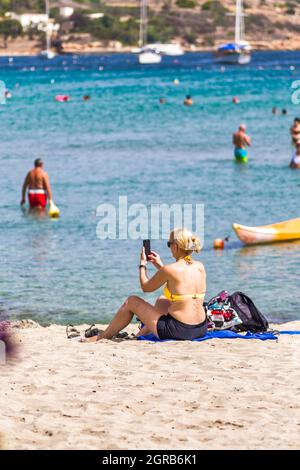 Malta: Una donna che si affaccia sul mare sulla spiaggia di Ghadira Bay. Foto Stock