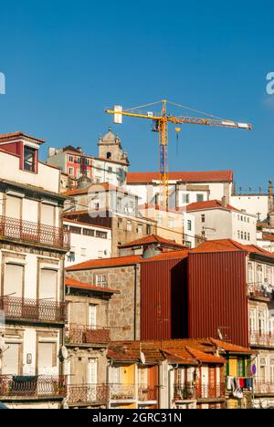 Vista tipica della città di Porto con strette strade antiche e case colorate vicine l'una all'altra salendo sulla collina e la gru in elevazione città storica Foto Stock