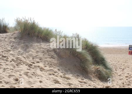 Camber, East Sussex, UK - 06.10.21: Sabbia campanaria East Sussex UK - vista delle dune di sabbia campanaria con cielo e mare dune tenute insieme con erbe Foto Stock