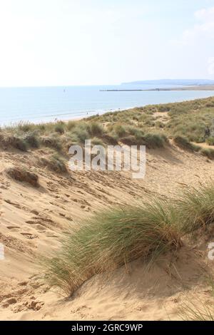 Camber, East Sussex, UK - 06.10.21: Sabbia campanaria East Sussex UK - vista delle dune di sabbia campanaria con cielo e mare dune tenute insieme con erbe Foto Stock