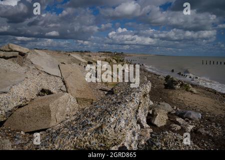 Climping Beach nel sud dell'Inghilterra e la difesa del mare rotto che si posa lungo la spiaggia. Foto Stock