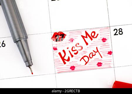 Promemoria per la scrittura Kiss Me Day nel calendario con penna. Agosto 27 Foto Stock
