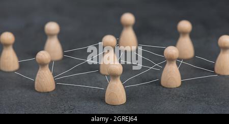 Wood figures, roup of people connecting through a web, business networking and communication Foto Stock