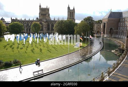 La gente cammina accanto a Luke Jerram's in Memoriam, un'installazione d'arte potente e significativa, creata in memoria delle perdite subite durante la pandemia COVID-19, dopo che è stata installata nel Bristol's College Green. L'installazione, che sarà aperta al pubblico dal 1° al 17 ottobre, è composta da oltre 100 bandiere di lenzuola ospedaliere NHS. Data foto: Venerdì 1 ottobre 2021. Foto Stock