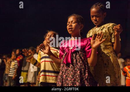 Indonesia, Papua, città di Sentani, messa evangelica, giovani ragazze che pregano Foto Stock