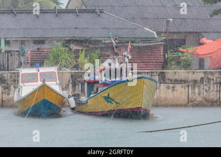 Indonesia, Papua, Isola di Biak, barche da pesca ormeggiate sotto la pioggia battente Foto Stock