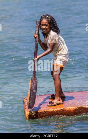 Indonesia, Papua, isola di Biak, giovane ragazza sorridente che gioca con una zattera sul mare Foto Stock